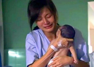 Maminka se slzami v očích zvedá své mrtvé děťátko. Upřeně sledujte jeho malou ručičku...