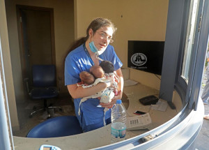 Zdravotní sestřička zachránila v bejrútské nemocnici tři novorozená miminka. Fotka vznikla několik minut po výbuchu dusičnanu amonného